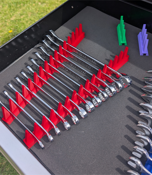 Red modular spanner organiser holding a set of combination spanners inside a professional toolbox drawer.