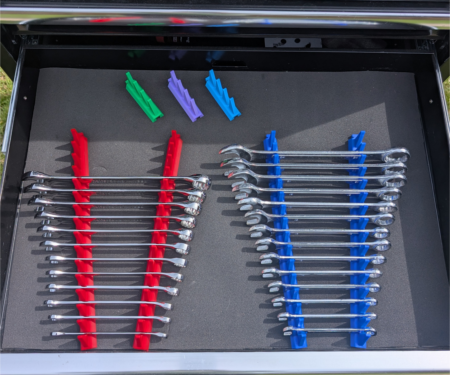 Modular spanner organisers installed in a toolbox drawer holding combination and ratchet spanners in an organised layout.