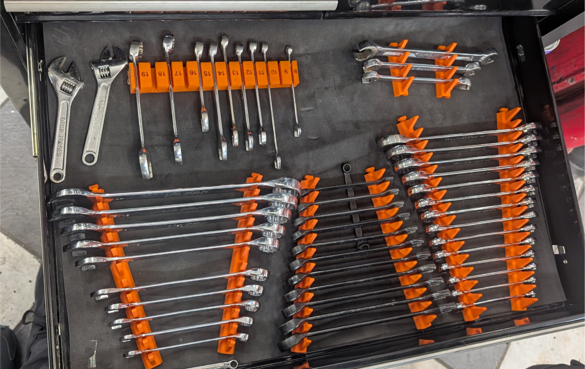 Set of wrenches in a tool drawer with in orange 