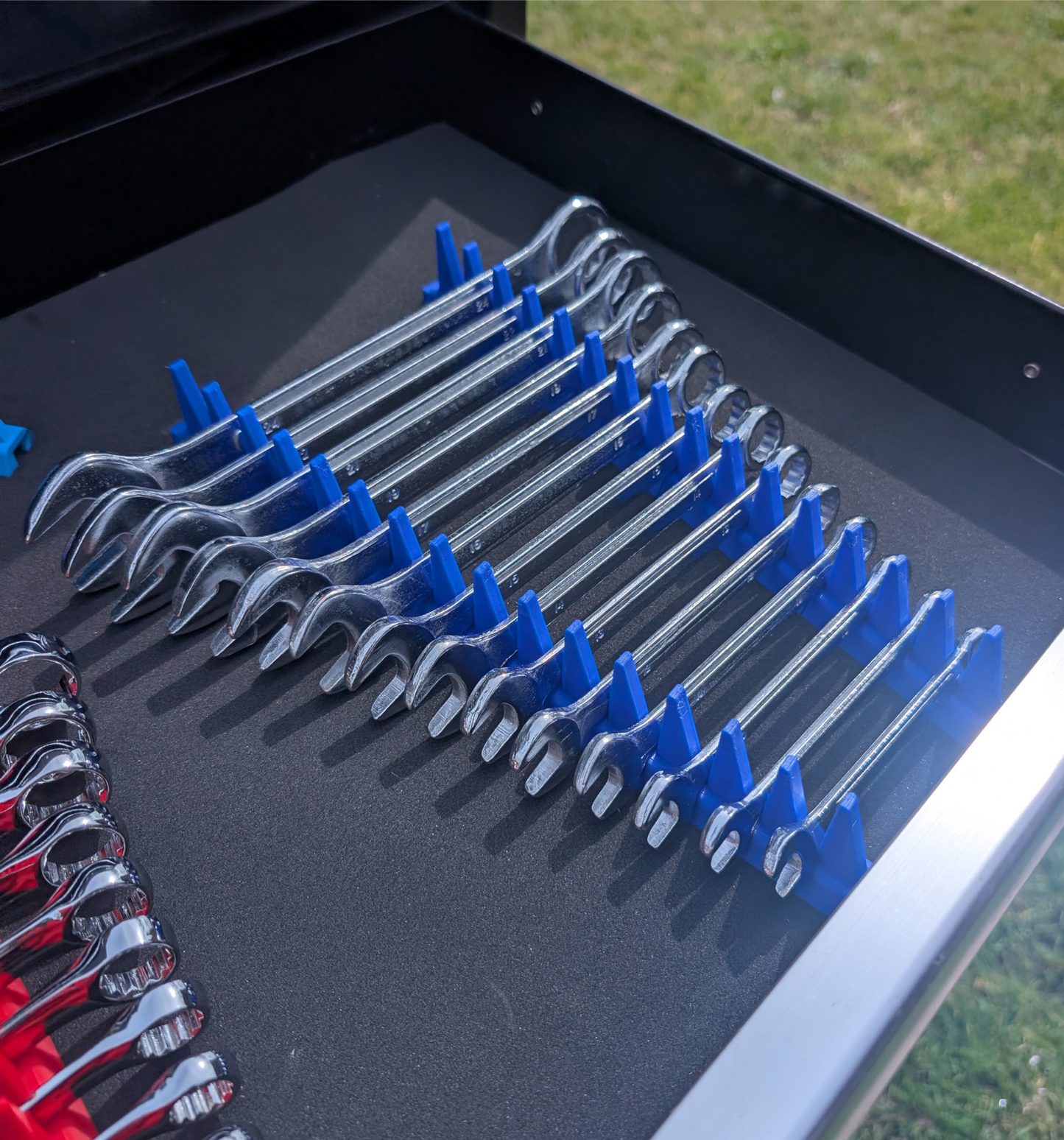 Blue modular spanner organiser displaying a neatly arranged combination spanner set in a toolbox drawer.